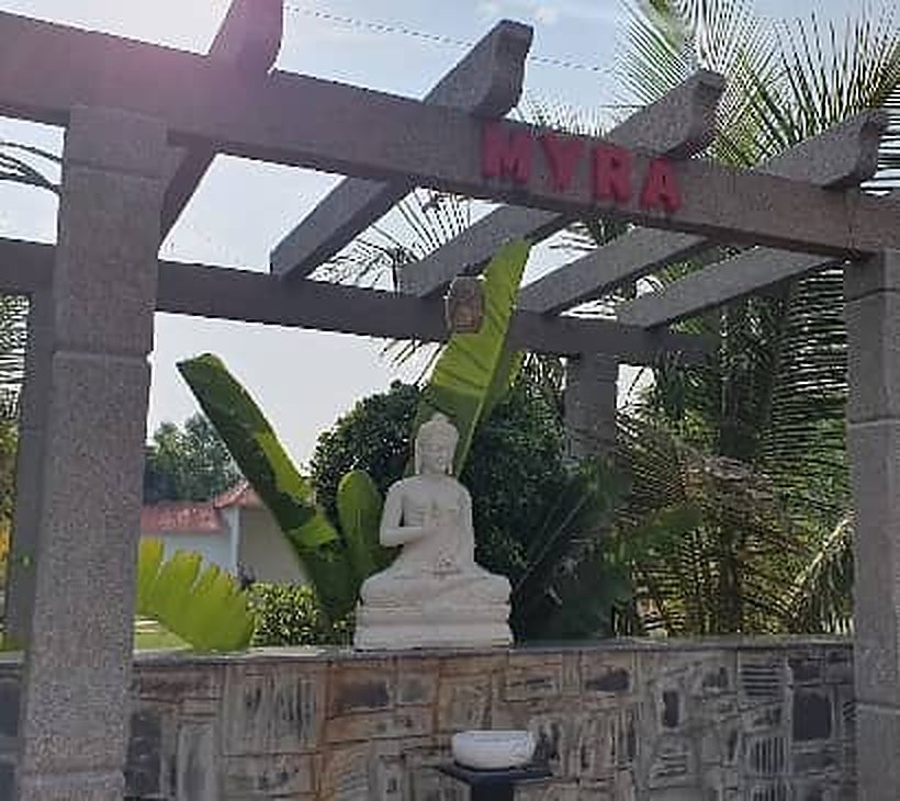 Stone pergola and Buddha statue in the garden at Myra Golden Beach Resort