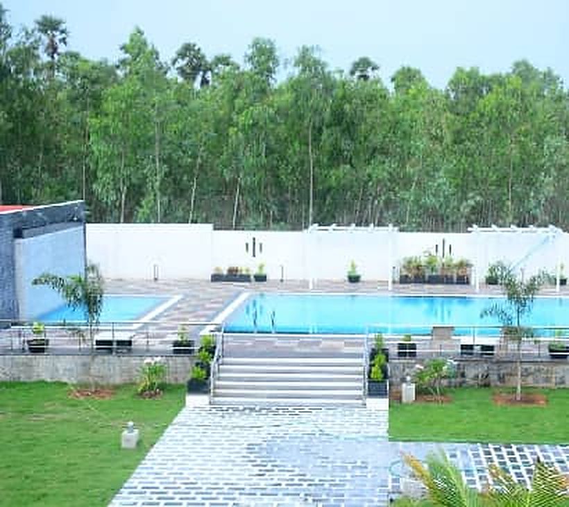 Swimming pool and lawn at Myra Golden Beach Resort, Chirala